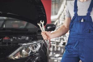 Hand of car mechanic with wrench. Auto repair garage.